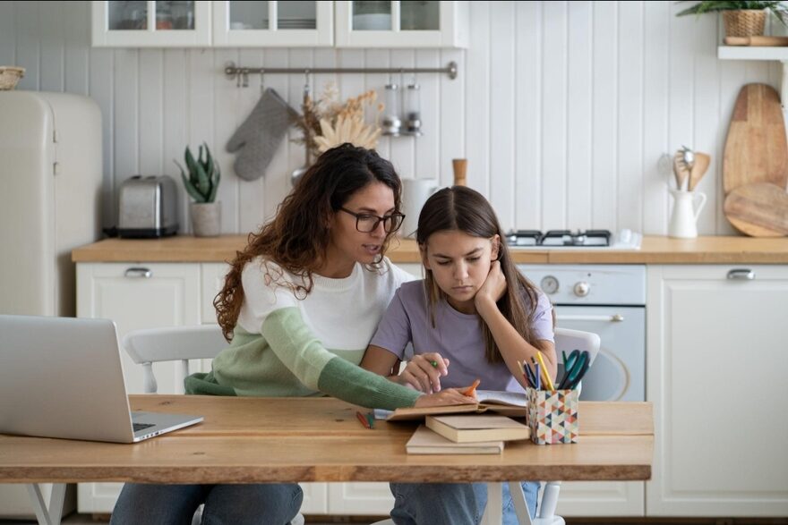 A parent and child study together at home, keeping skills sharp over the summer.